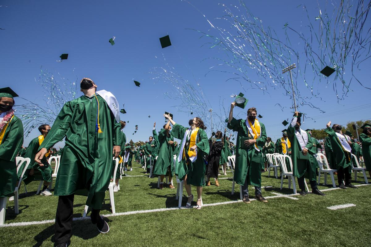 Graduating seniors toss their mortarboards in the air during the Costa Mesa High School commencement.