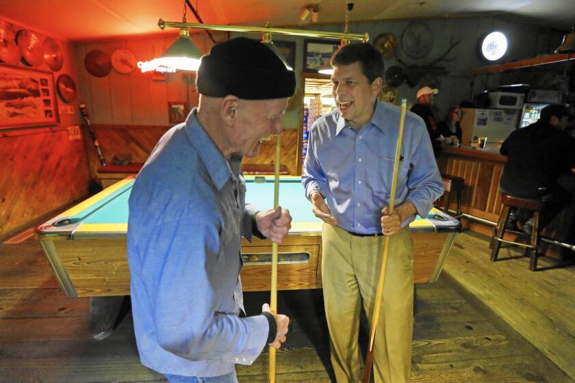 Democratic Sen. Mark Begich, right, jokes with Jimmy Maddox this month at Kito's Kave, a bar in Petersburg, Alaska.