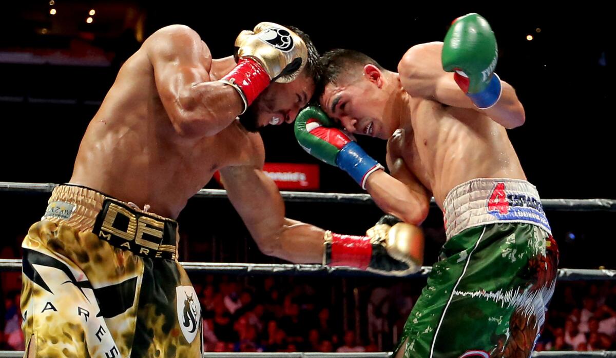 Abner Mares, left, and Leo Santa Cruz exchange punches during their featherweight fight Saturday night at Staples Center.