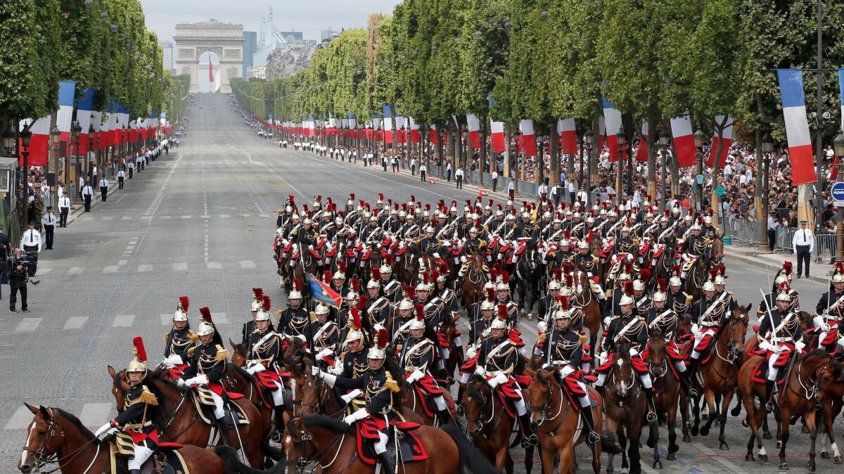 Mounted Republican Guards ride down the Champs-Elysees during the Bastille Day parade in Paris on July 14, 2015,