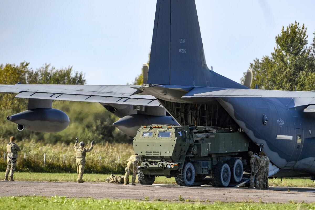FILE - Soldiers load a High-Mobility Artillery Rocket System (HIMARS ) from a US Special Operations MC-130J aircraft during military exercises at Spilve Airport in Riga, Latvia, on Sept. 26, 2022. A series of embarrassing military losses for Moscow in recent weeks has presented a growing challenge for prominent hosts of Russian news and political talk shows scrambling to find ways to paint Kyiv's gains in a way that is still favorable to the Kremlin. (AP Photo/Roman Koksarov, File)