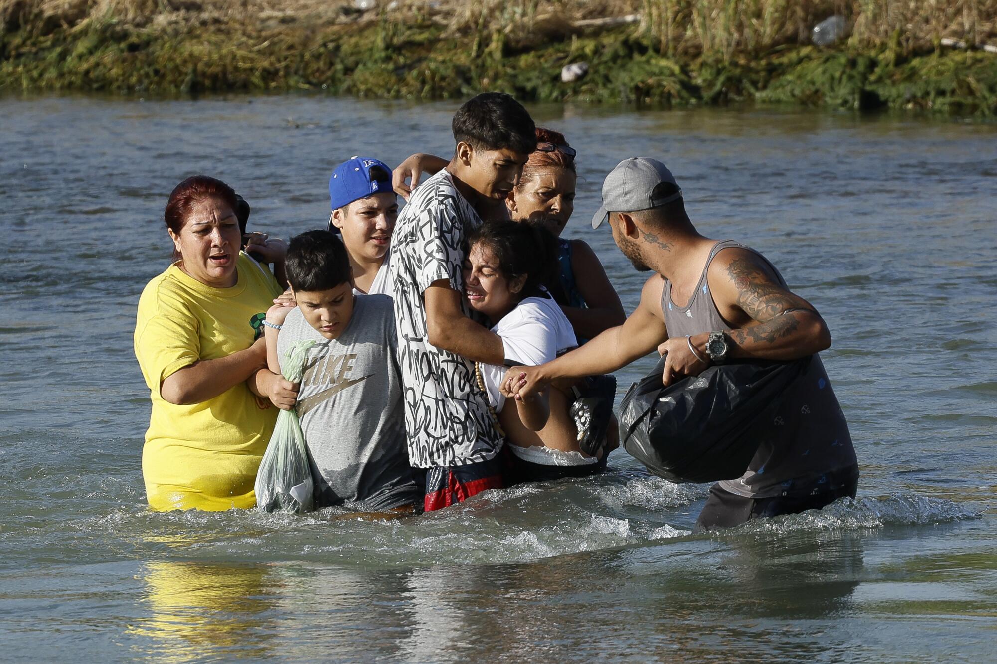 A group of migrants struggles to cross the Rio Grande. 