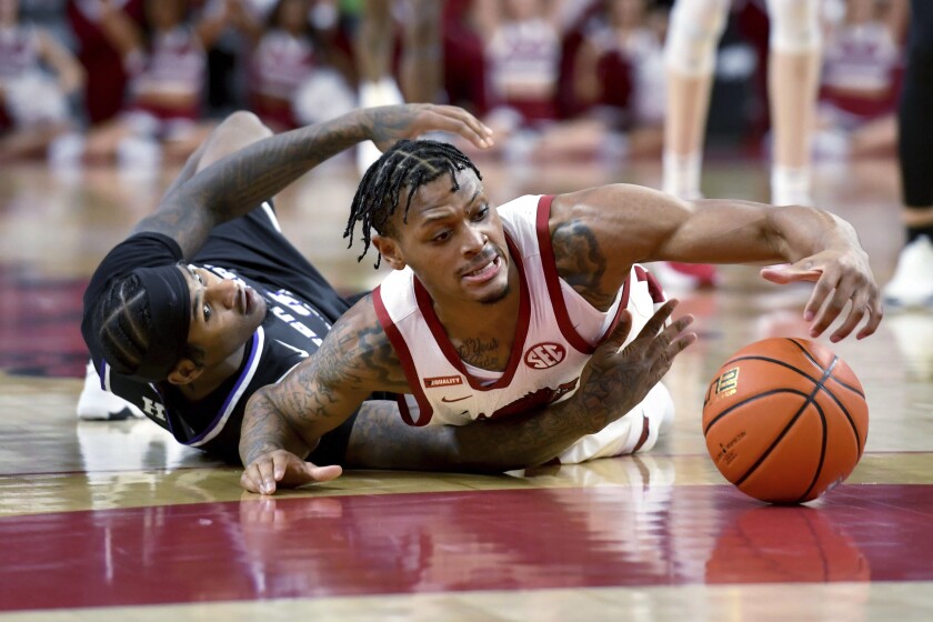 Central Arkansas guard Darious Hall, left, and Arkansas guard Au'Diese Toney (5) dive after a loose ball during the first half an NCAA college basketball game Wednesday, Dec. 1, 2021, in Fayetteville, Ark. (AP Photo/Michael Woods)