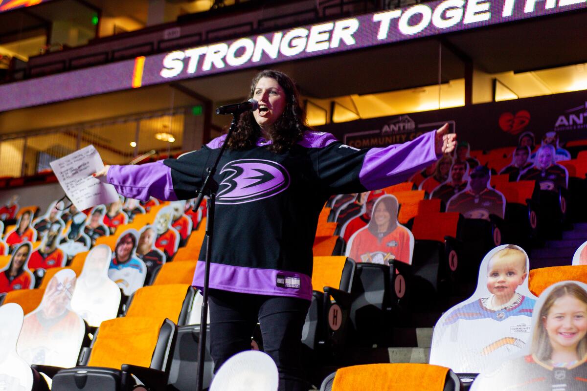 Arms wide open, Angelique Fong stands at a microphone and introduces the Ducks before their game April 11 at Honda Center.
