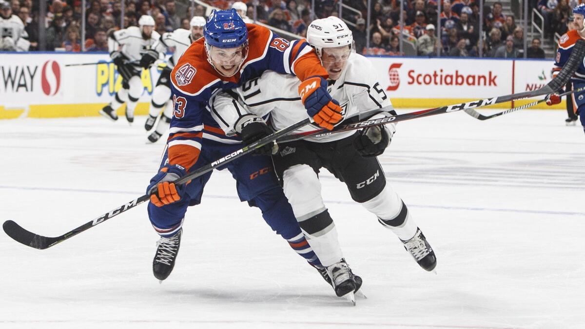 The Kings' Austin Wagner and the Edmonton Oilers' Matthew Benning race for the puck during a Nov. 29 game in Edmonton.