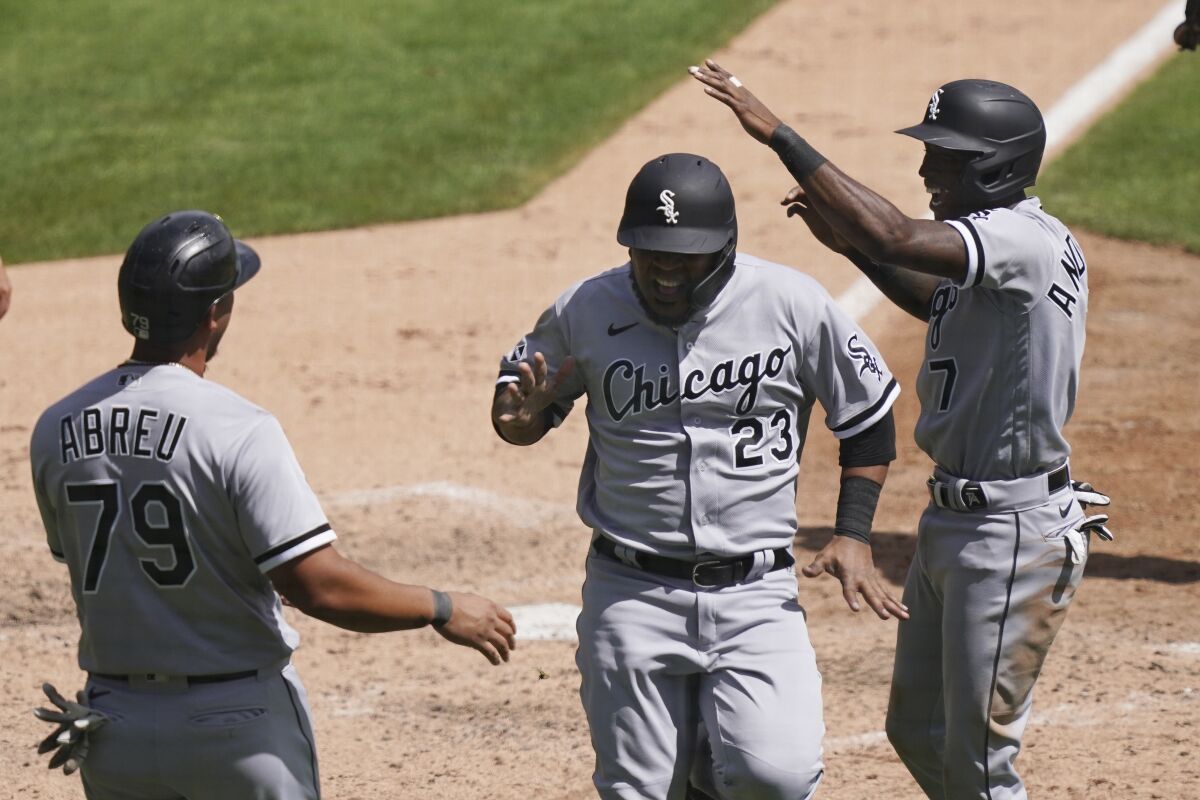 Chicago White Sox' Jose Abreu (79), Tim Anderson, right, and Edwin Encarnacion react after they all scored on teammate Luis Robert's double to right field during the fifth inning of a baseball game against the Detroit Tigers, Wednesday, Aug. 12, 2020, in Detroit. (AP Photo/Carlos Osorio)