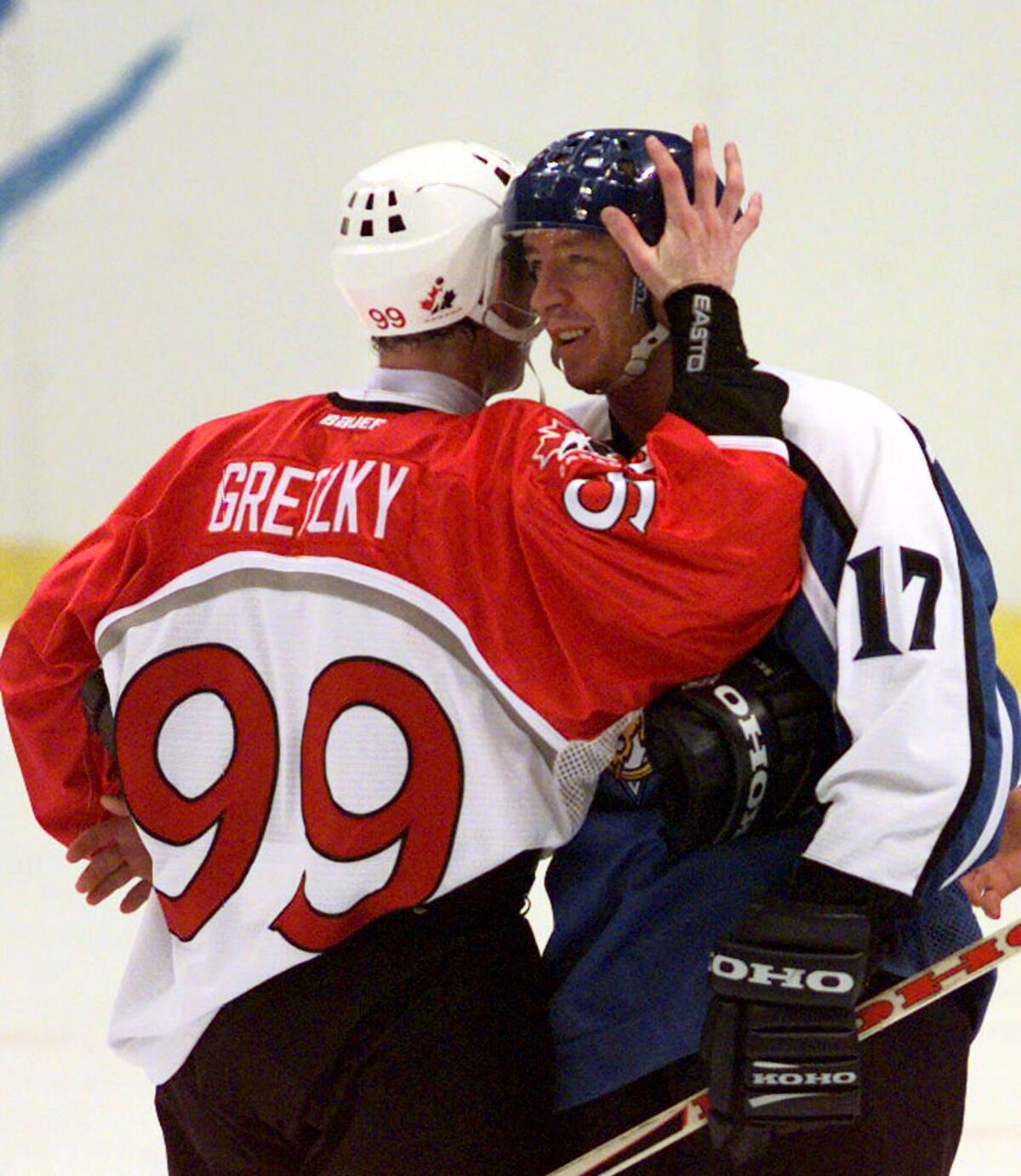 Wayne Gretzky and Jari Kurri embrace on the ice.