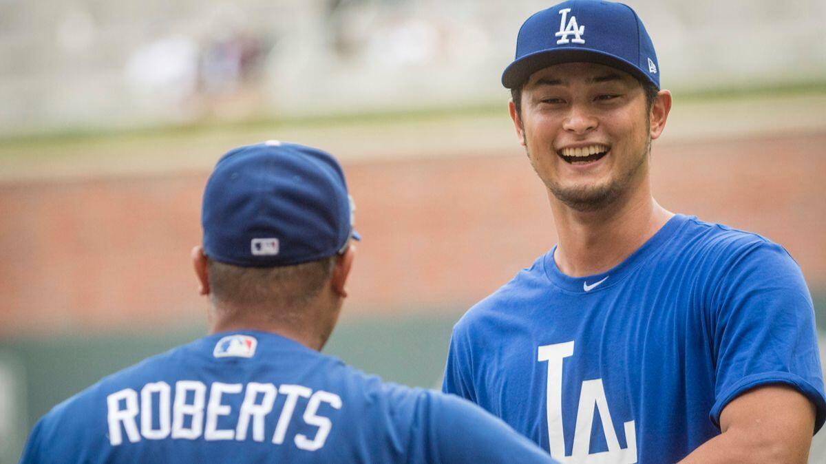Dodgers' Yu Darvish, right, talks to manager Dave Roberts before a game against the Atlanta Braves on Wednesday.