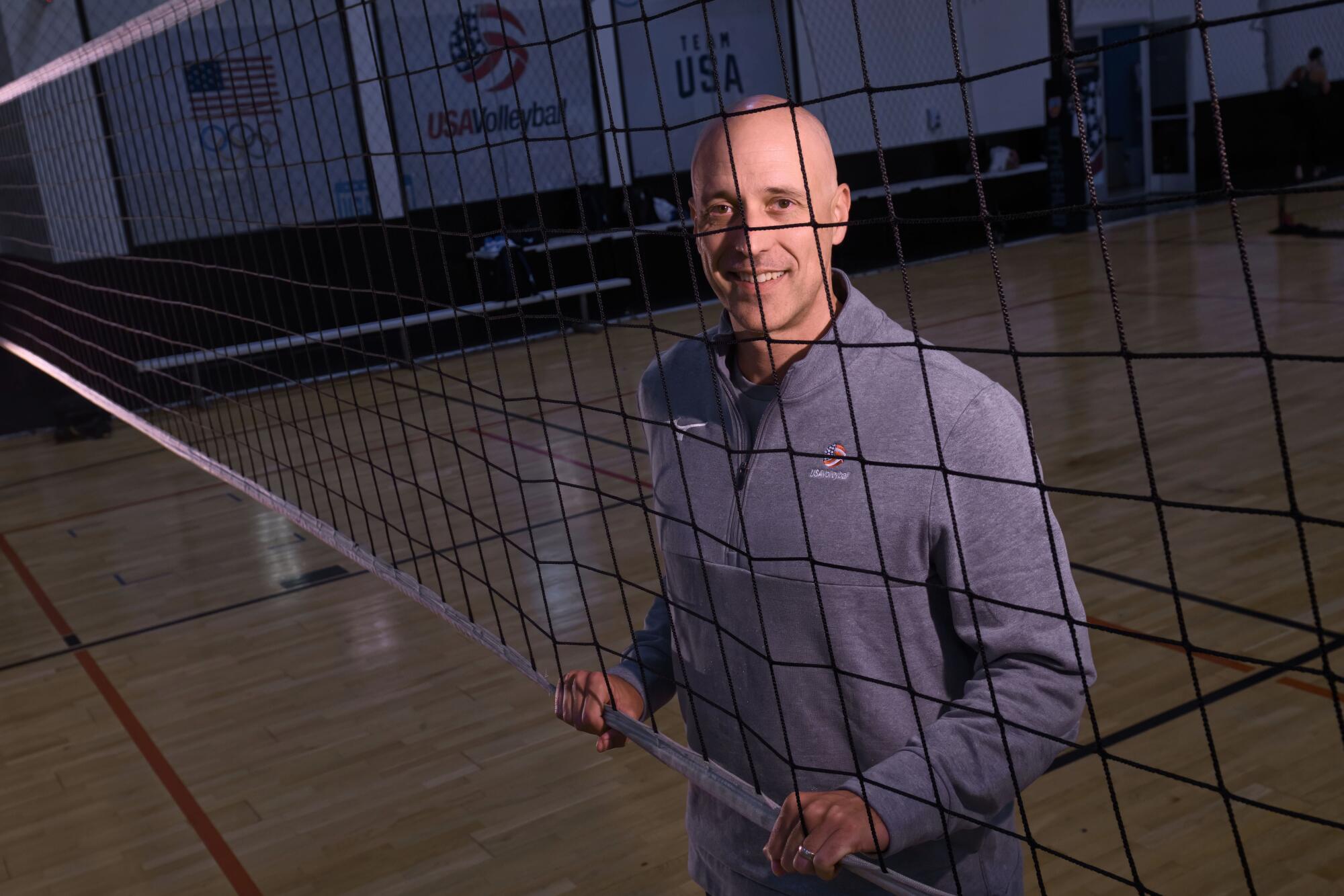 U.S. men's volleyball coach John Speraw stands behind a net at a team practice in Anaheim.