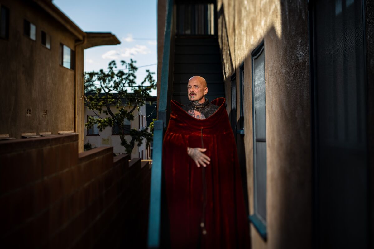 Ron Athey wears a red velvet robe on the stoop of of his Silver Lake apartment building