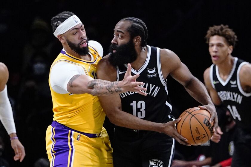 Los Angeles Lakers' Anthony Davis, left, defends Brooklyn Nets' James Harden.