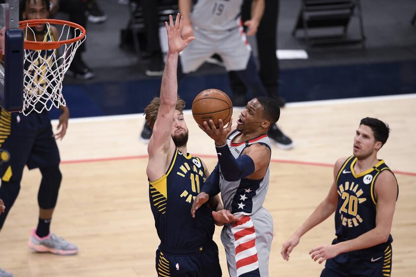 Washington Wizards guard Russell Westbrook, center, goes to the basket against Indiana Pacers forward Domantas Sabonis (11) and forward Doug McDermott (20) during the first half of an NBA basketball Eastern Conference play-in game Thursday, May 20, 2021, in Washington. (AP Photo/Nick Wass)