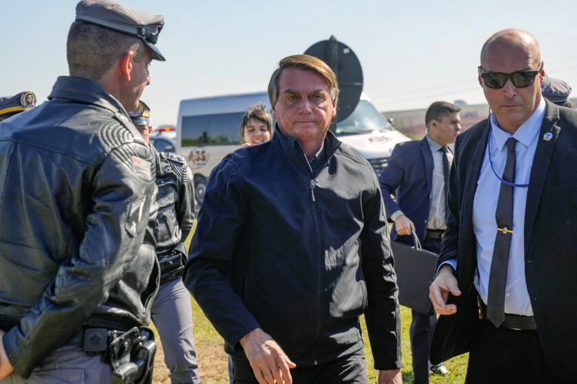 Brazilian President Jair Bolsonaro arrives to a resort hotel where he is expected to meet with Elon Musk in Porto Feliz, Brazil, Friday, May 20, 2022. The Telsa and SpaceX chief executive officer tweeted that he was in Brazil to help bring Internet service to rural schools in the Amazon and to help monitor the Amazon environmentally. (AP Photo/Andre Penner)