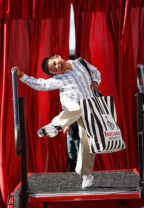 Jeovanny Moreno, 8, shows off his new clothes, backpack and school supplies worth about $400. Shoes from Foot Locker and food from In-N-Out Burger were also provided to thousands of needy children at the back-to-school giveaway at the Fred Jordan Mission.