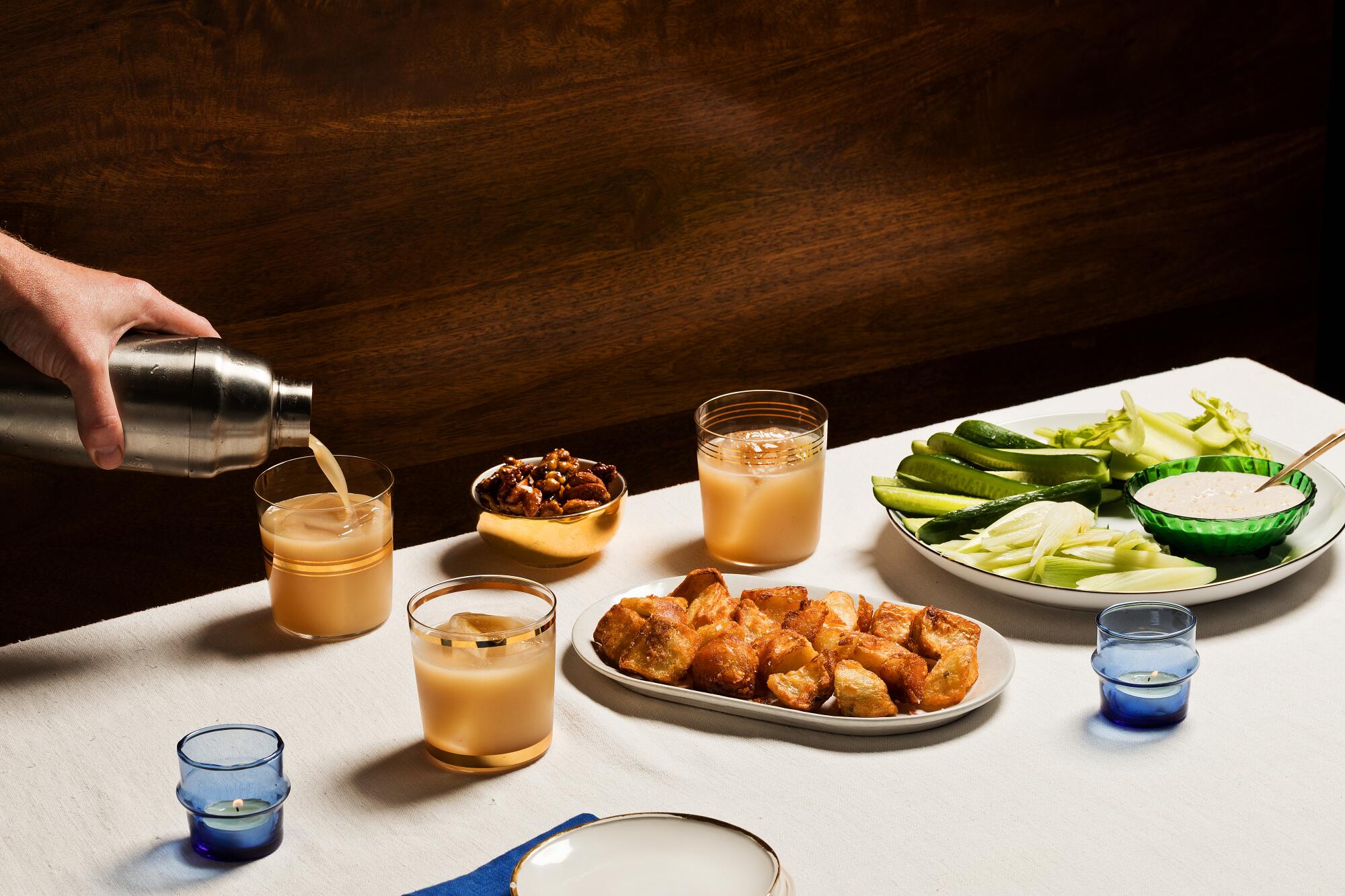 To start the holiday feast, a cocktail, fried potatoes and crudité with Caesar sour cream and spiced mixed nuts.