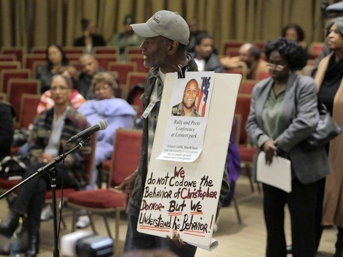 Community activist Morris Griffin holds a sign that echoed sentiments among some audience members at a community meeting in South L.A. in which residents could speak with LAPD Chief Charlie Beck about the department and Christopher Dorner's manifesto blaming his firing from the department on racists.
