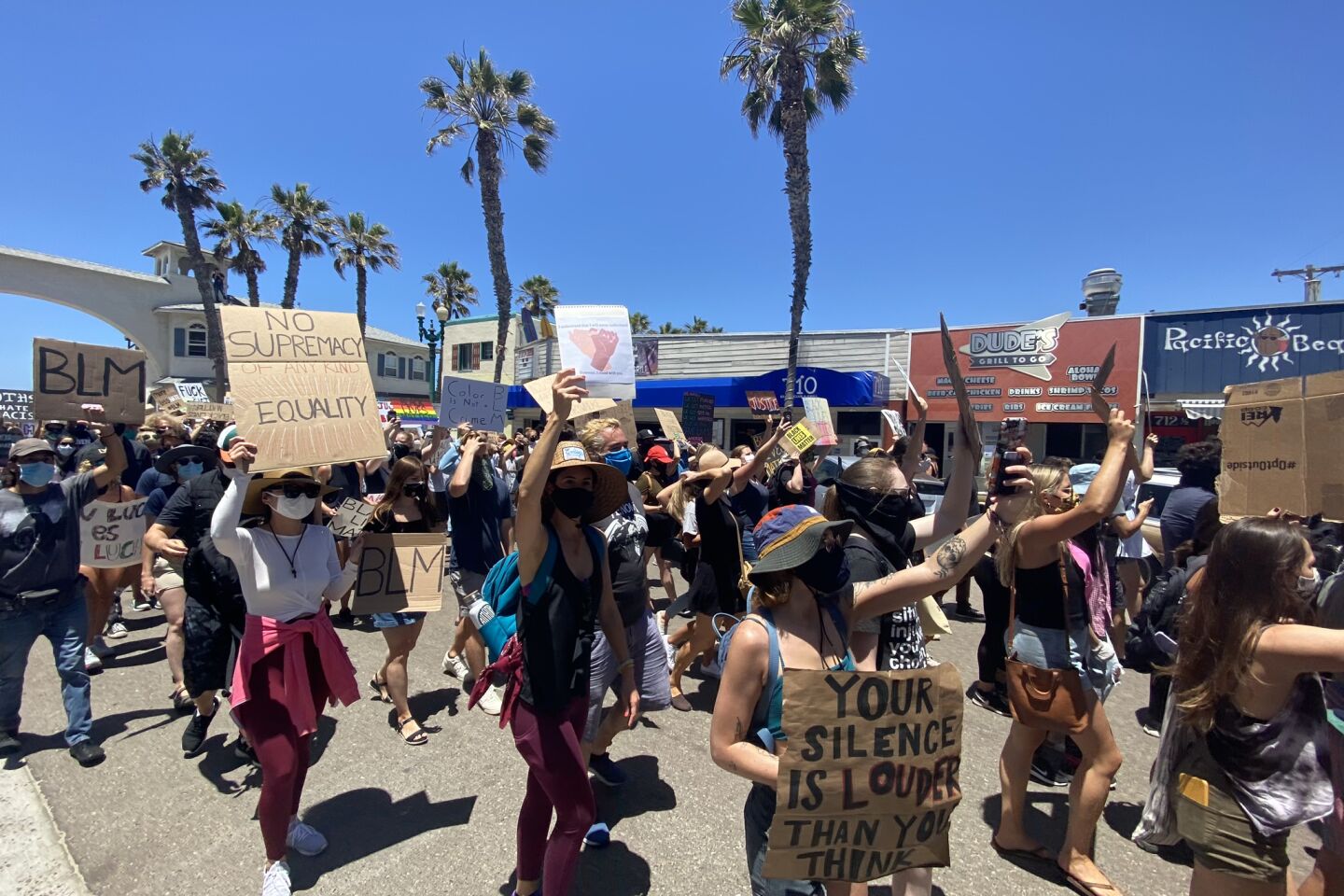 Participants show their messages in the Pacific Beach Walk for Equality.