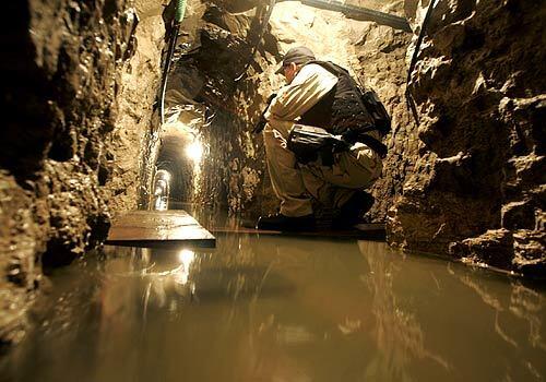 An Immigration Customs Enforcement agent walks down one of the longest, widest and tallest tunnels discovered beneath the US-Mexico border. Like this one, many tunnels along the border have not been completely filled in.