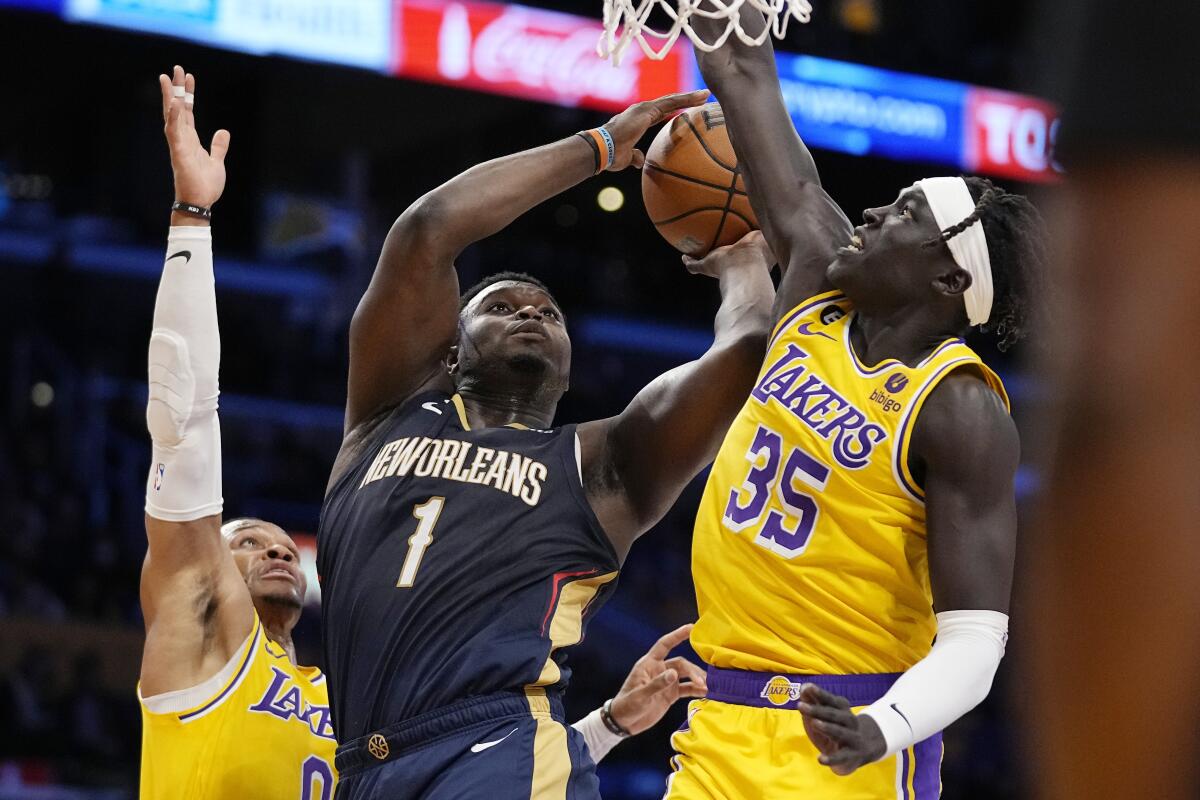 New Orleans Pelicans forward Zion Williamson shoots as Lakers guard Russell Westbrook and forward Wenyen Gabriel defend.