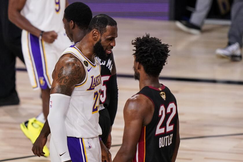 Los Angeles Lakers' LeBron James (23) talks to Miami Heat's Jimmy Butler (22) during the first half in Game 3 of basketball's NBA Finals, Sunday, Oct. 4, 2020, in Lake Buena Vista, Fla. (AP Photo/Mark J. Terrill)