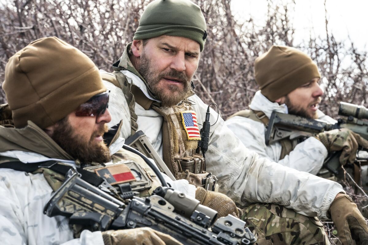 Three men in the woods wearing camouflage and holding rifles in "SEAL Team" on CBS.