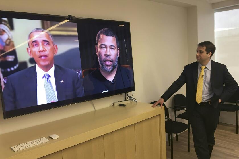 Paul Scharre views in his offices in Washington, DC January 25, 2019 a manipulated video by BuzzFeed with filmmaker Jordan Peele (R on screen) using readily available software and applications to change what is said by former president Barack Obama (L on screen), illustrating how deepfake technology can deceive viewers. - "Deepfake" videos that manipulate reality are becoming more sophisticated and realistic as a result of advances in artificial intelligence, creating a potential for new kinds of misinformation with devastating consequences. (Photo by Robert LEVER / AFP) / TO GO WITH AFP STORY by Rob LEVER "Misinformation woes may multiply with deepfake videos" (Photo credit should read ROBERT LEVER/AFP via Getty Images)