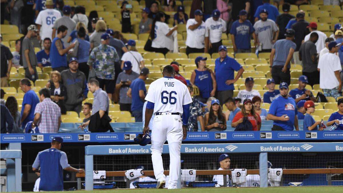 Dodgers Yasiel Puig walks off the field after hitting into a double play to end the game against the Angels, Monday.