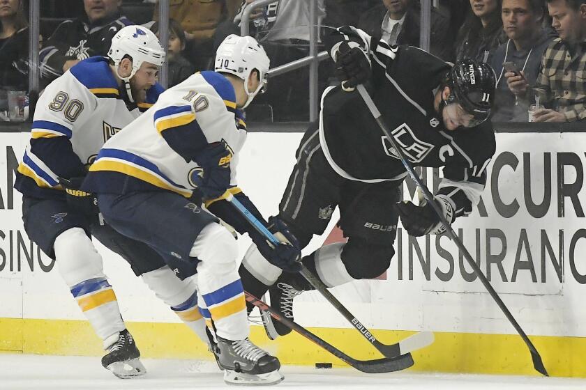 Los Angeles Kings center Anze Kopitar, right, trips as he competes for the puck with St. Louis Blues center Ryan O'Reilly, left, and center Brayden Schenn during the third period of an NHL hockey game Thursday, March 7, 2019, in Los Angeles. The Blues won 4-0. (AP Photo/Mark J. Terrill)