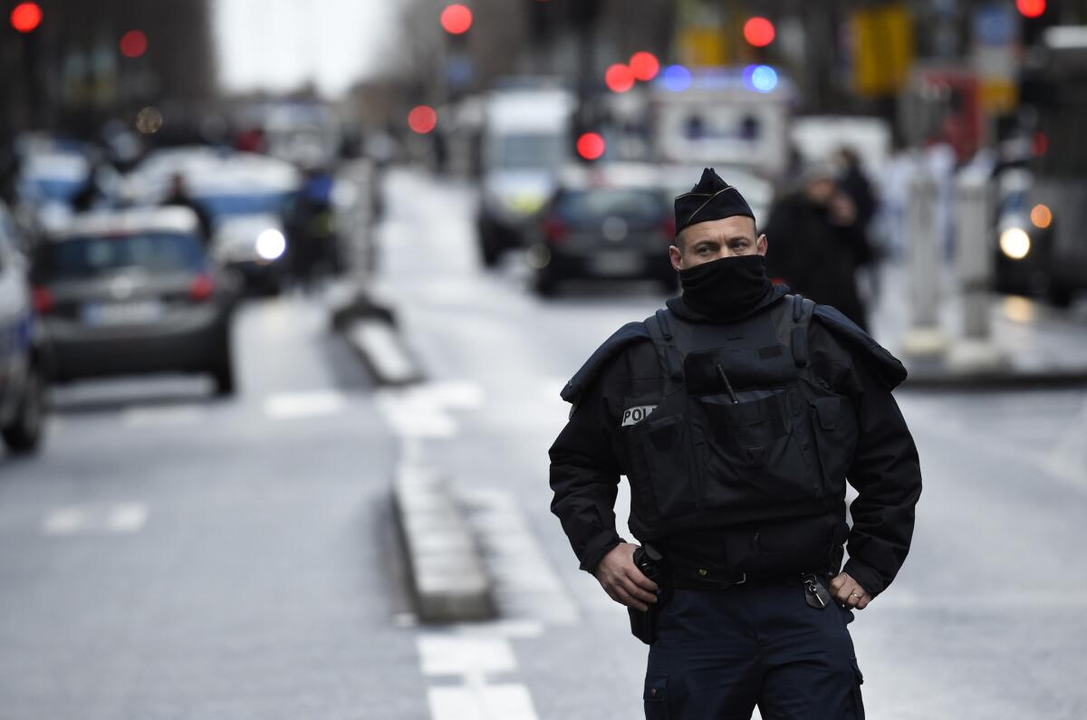 A French police officer stands at the Boulevard de Barbes in north Paris after a man armed with a knife and wearing what appeared to be an explosives vest was fatally shot at a police station.