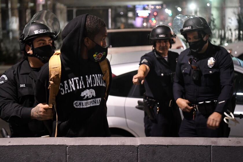 LOS ANGELES, CALIFORNIA NOVEMBER 3, 2020-LAPD officers arrest a protestor along Figueroa St. in Downtown Los Angeles Tuesday night. (Wally Skalij/Los Angeles Times)