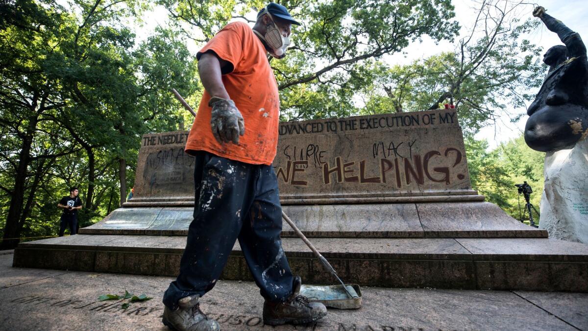 City workers remove graffiti from the base of what was once the Jackson-Lee Monument, a Confederate statue that was removed from a Baltimore park Aug. 16.