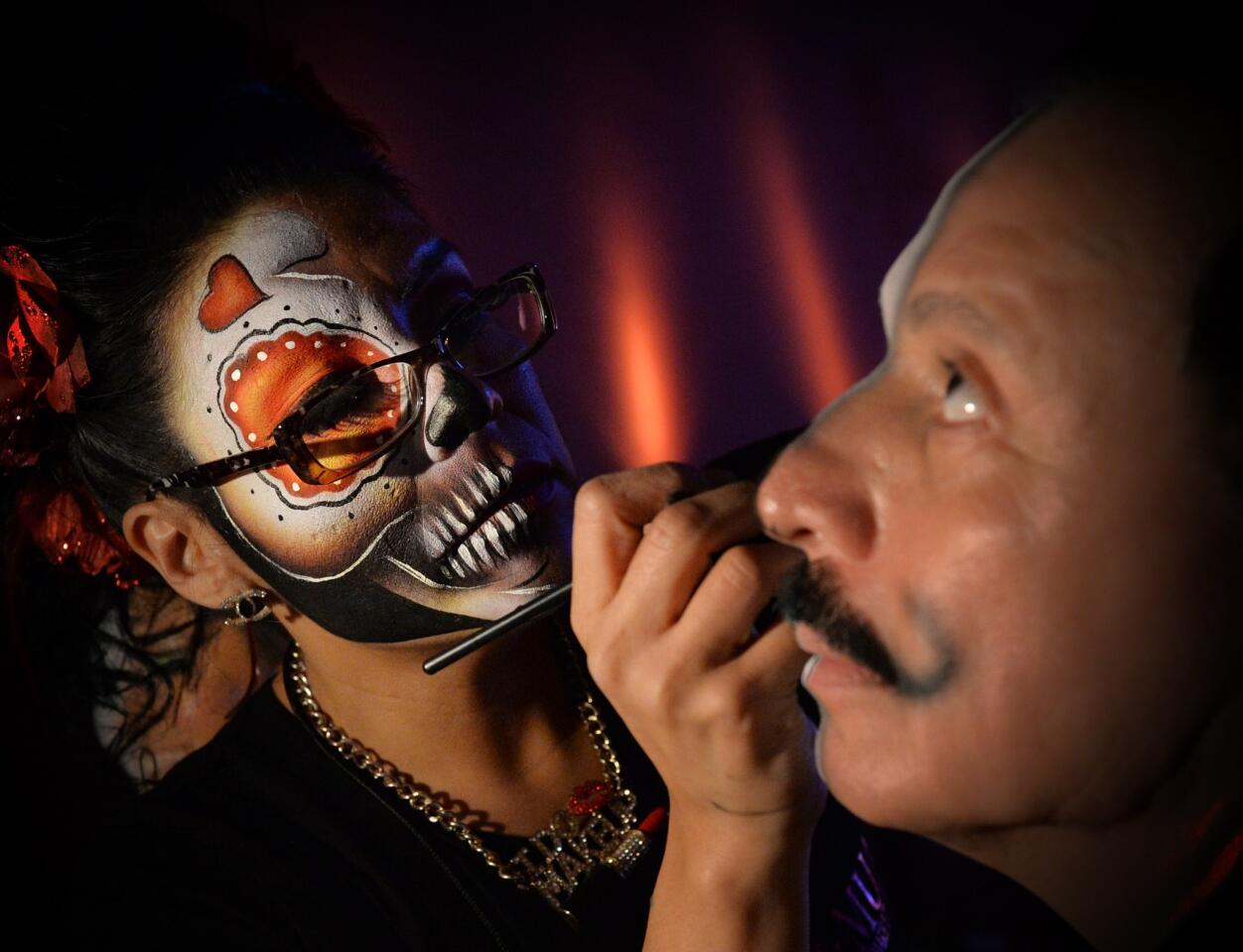 People practice their makeup for the coming festival of Día de los Muertos at the Hollywood Forever Cemetery.