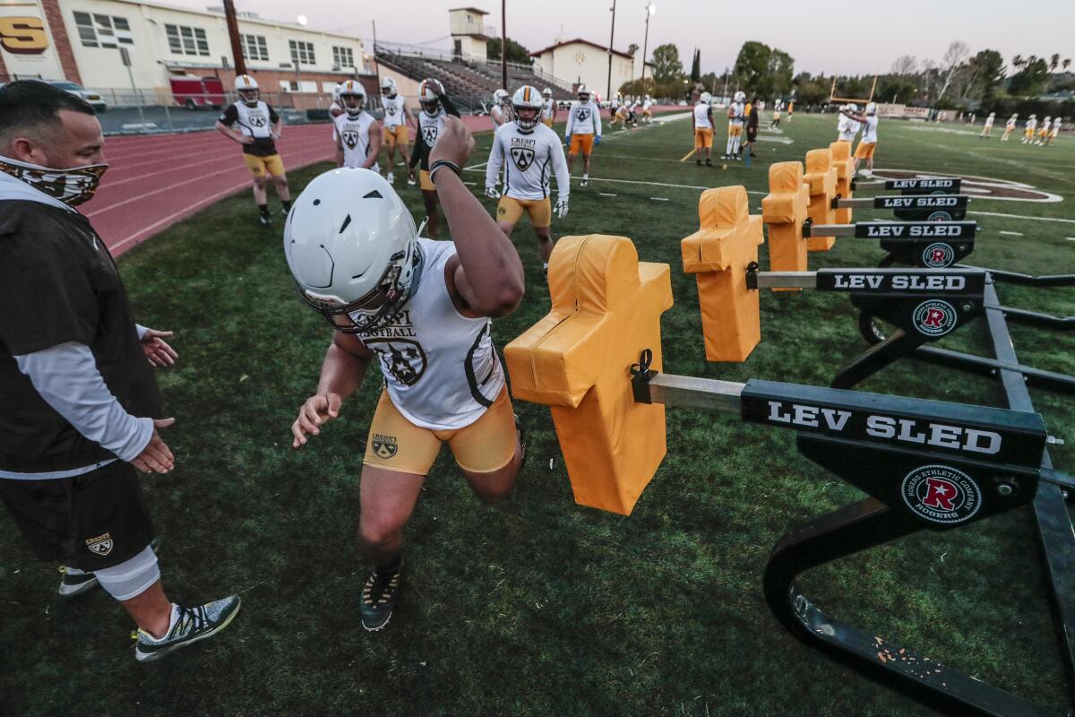 Crespi High football players practice on the field.