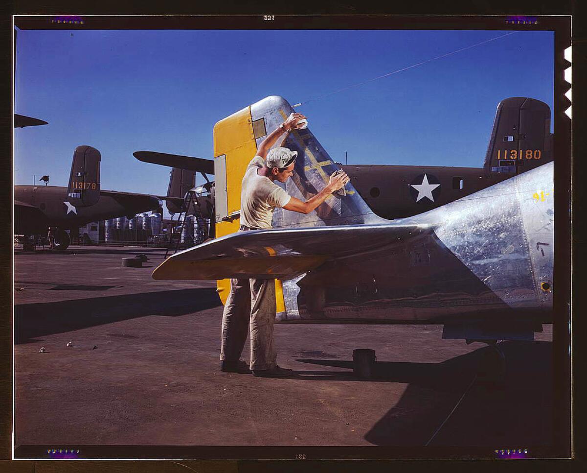 On North American's outdoor assembly line, a painter cleans the tail section of a P-51 fighter before spraying the olive-drab camouflage of the U.S. Army, North American Aviation Inc. in Inglewood in October 1942.