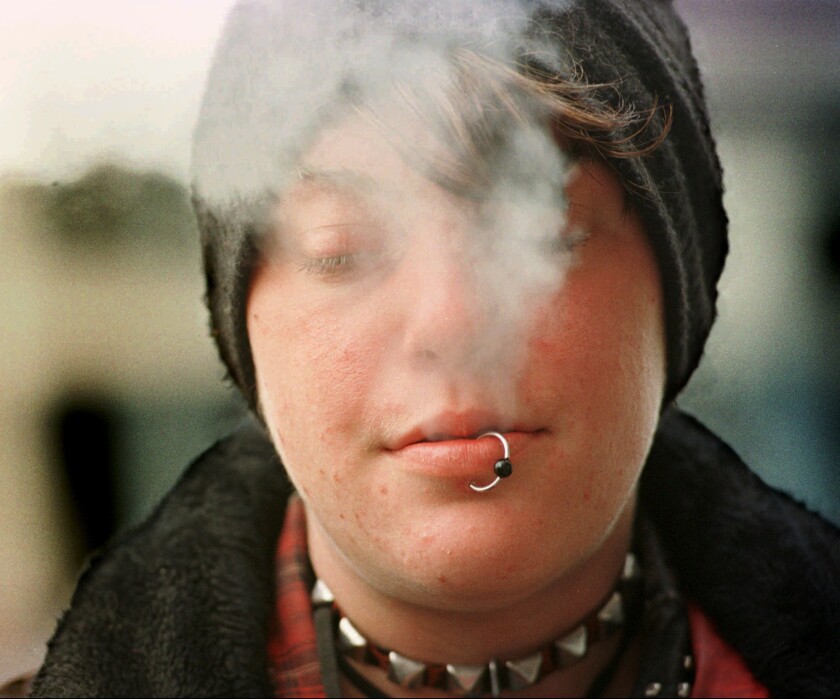 Nicole, 19, exhales smoke from her cigarette while hanging out on Haight Street July 17, 1996, in San Francisco.