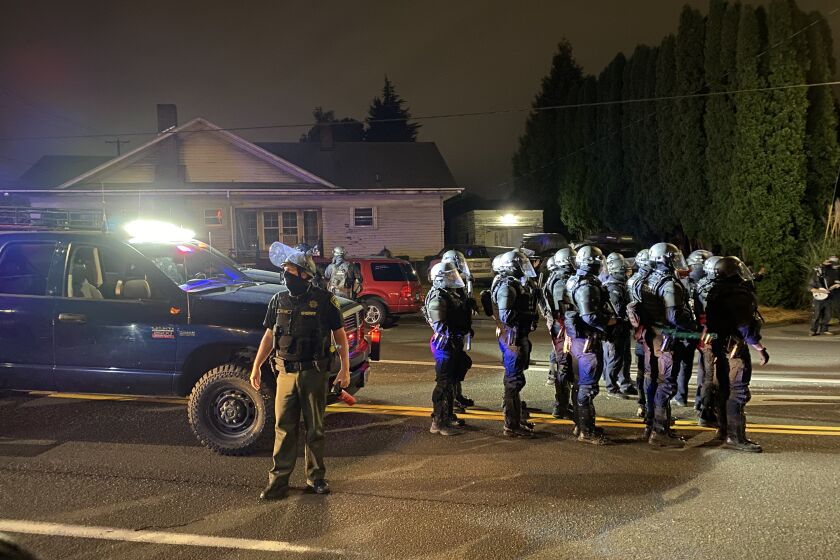 Multnomah County Sheriff’s deputies in Portland line up to clear protesters off a street.