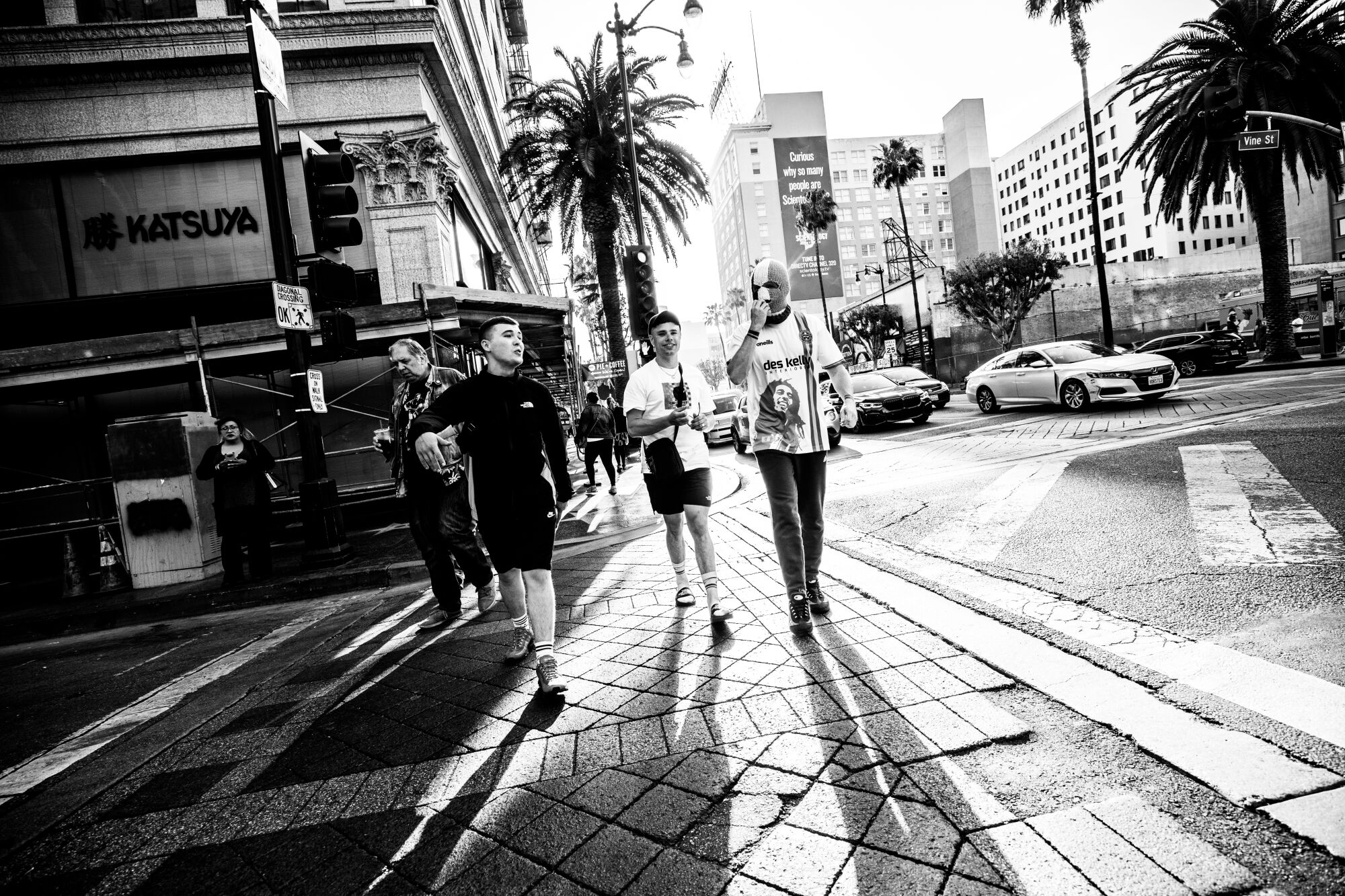 Three band members cross a Hollywood street.