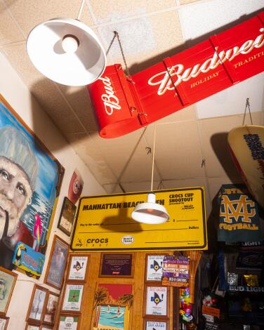 Decor in a bar includes a red Budweiser sign and a big fake check to a volleyball tournament winner.