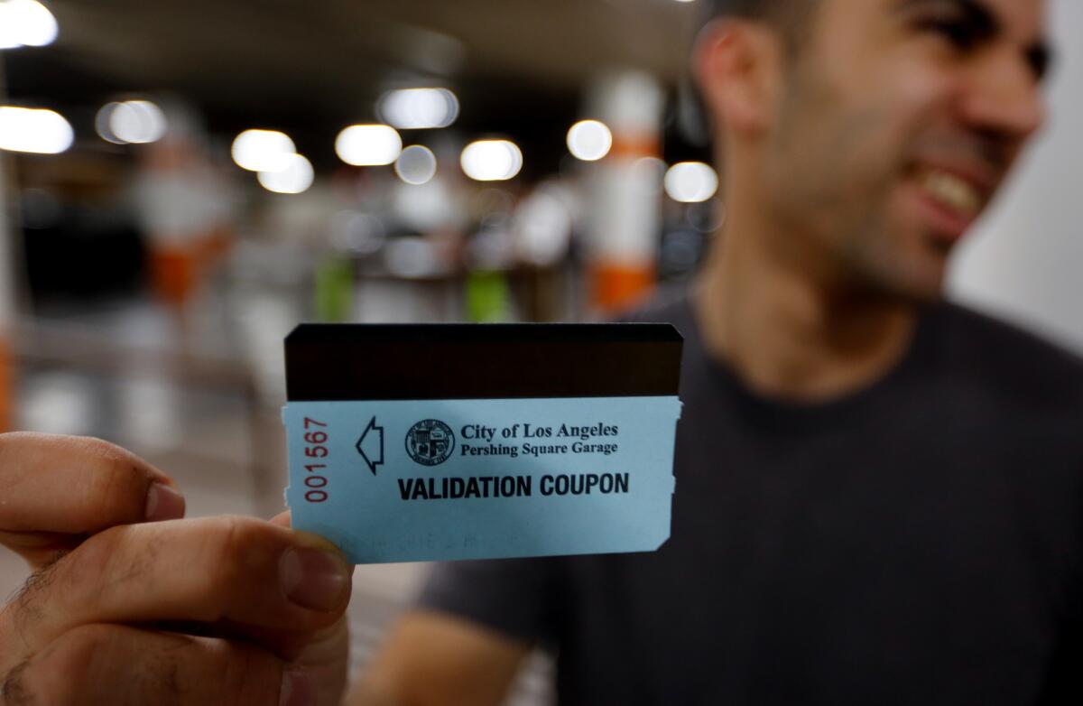 Downtown Los Angeles employee Andy Agopyan holds his ticket voucher in the Pershing Square garage. Thanks to a class-action lawsuit, parking is free in the Pershing Square underground parking garage for a limited time.