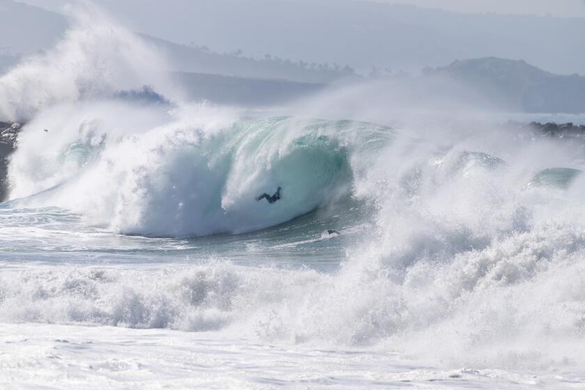Newport Beach, CA - June 9: A surfer wipes out, while a body boarder duck-dives a large wave at The Wedge in Newport Beach as a south-southwest swell brings high surf on Tuesday, June 9, 2026. (Allen J. Schaben / Los Angeles Times)