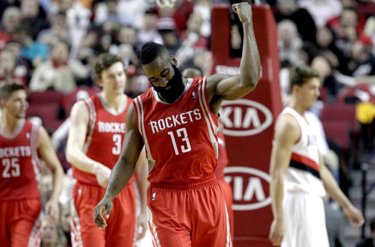 Rockets guard James Harden celebrates after making a three-point shot against the Trail Blazers on Tuesday.