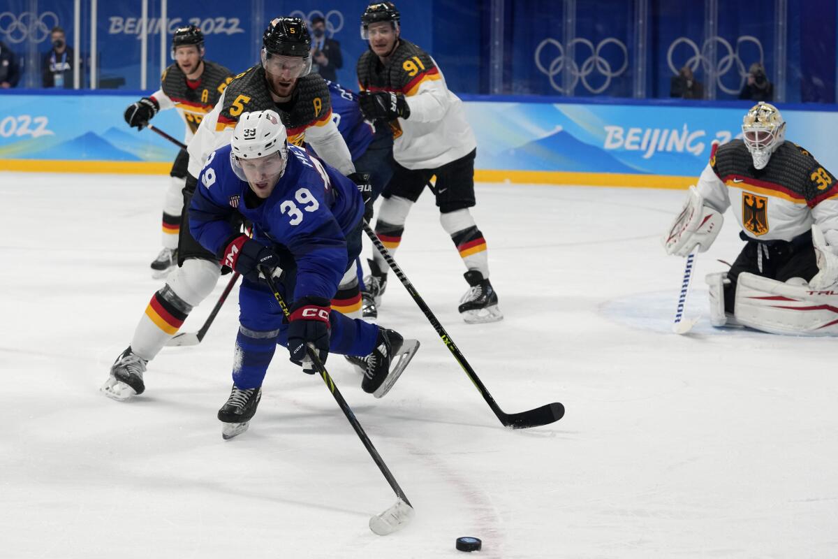 United States' Ben Meyers goes for the puck in front of Germany's Korbinian Holzer.