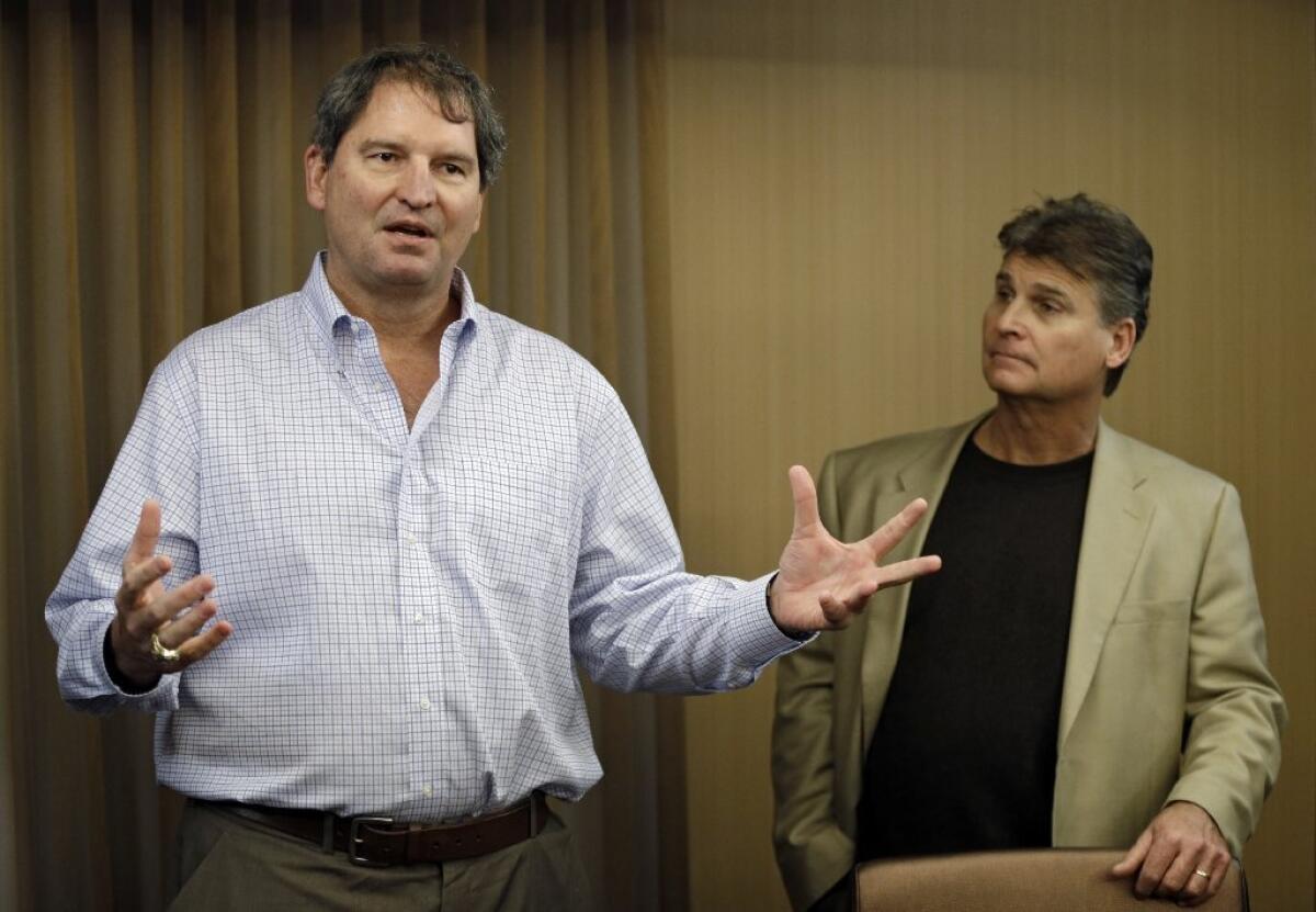 Former Cleveland Browns quarterback Bernie Kosar, left, speaks at a news conference with Dr. Rick Sponaugle, right.