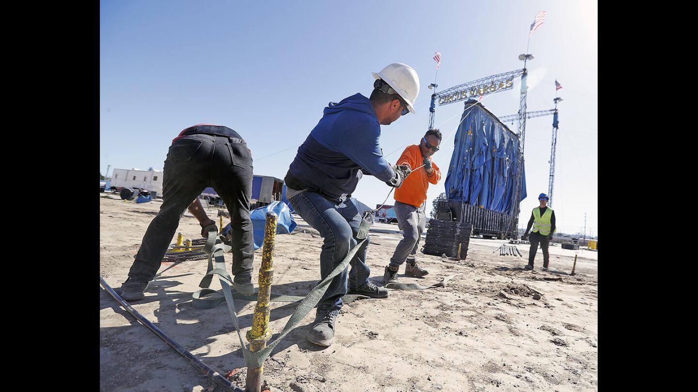 A Circus Vargas crew works together to pull a strap taut to secure it to a post as they hoist the big top on a lot adjacent to the southbound 5 Freeway near Burbank Boulevard on Tuesday, April 17, 2018.