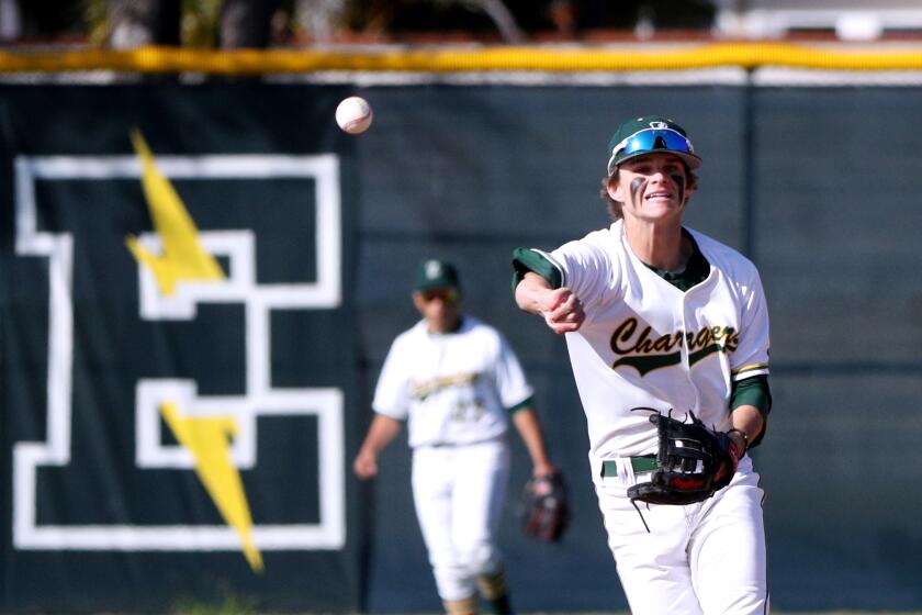 Edison High baseball player Tyler Weaver throws the runner out in home game vs Laguna Beach High, at the Chargers home field in Huntington Beach on Friday, March 6, 2020.