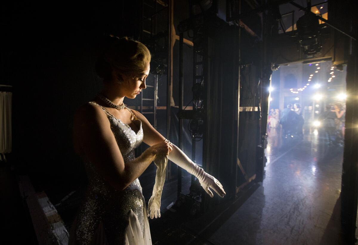 Ashley Shaw puts on long white gloves backstage before going out to play Cinderella.