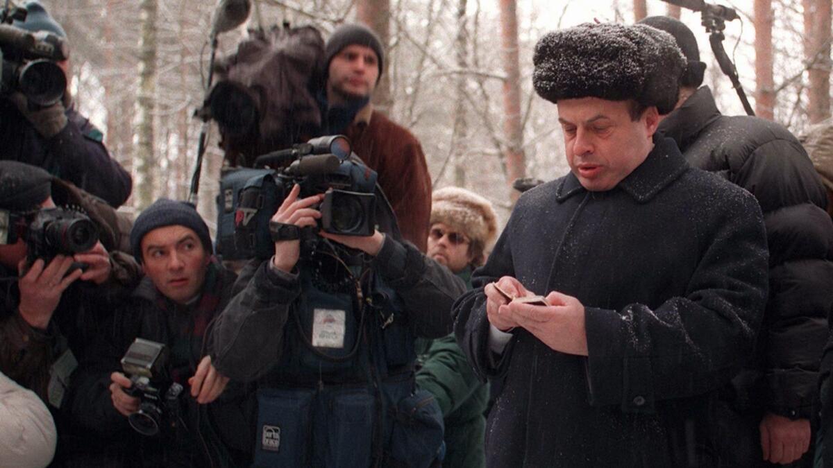 Then-Israeli Trade Minister Natan Sharansky holds his prayerbook at the grave of Andrei Sakharov, the human rights activist and Nobel Peace Prize winner, in Moscow on Jan. 28, 1997.