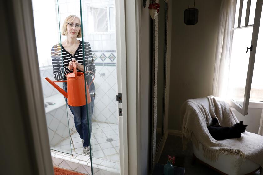 SANTA MONICA-CA-MAY 26, 2022: Environmentalist Zan Dubin-Scott is photographed at home in Santa Monica on Thursday, May 26, 2022. Dubin-Scott has started placing a watering can in her shower to capture the water as it heats up, then uses it to water her potted plants. (Christina House / Los Angeles Times)