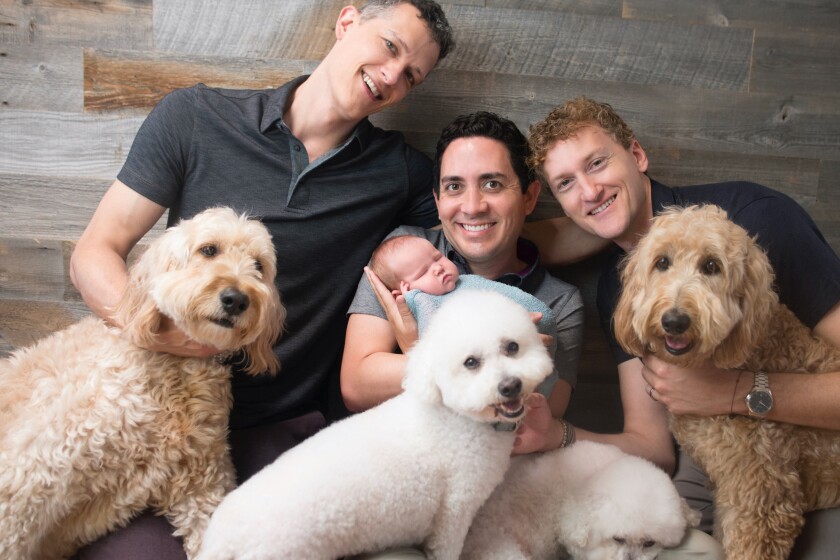 Dr. Ian Jenkins, left, with his partners Alan and Jeremy, their daughter, Piper, and dogs in 2017.