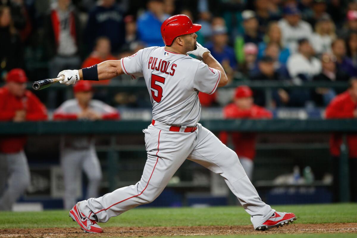 Angels first baseman Albert Pujols (5) hits a three-run home run against the Mariners in the ninth inning on May 14.